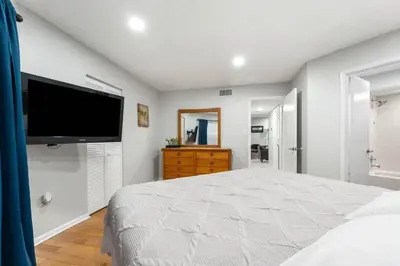a bedroom with a large bed and a flat screen tv at 3697 Orlando Vacational Apartment in Orlando