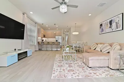a living room with a couch and a flat screen tv at New Cozy & Spacious Townhouse near Disney - 4BR, 3FB, and Pool in Orlando