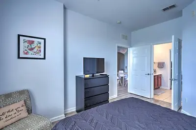 a bedroom with a bed and a tv on a dresser at NEW! Luxury Condo, Min to DisneyConvention Center in Orlando