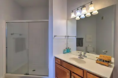 a bathroom with a sink and a shower with a mirror at NEW! Luxury Condo, Min to DisneyConvention Center in Orlando