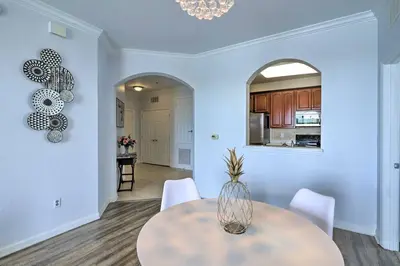 a dining room with a table and white chairs at NEW! Luxury Condo, Min to DisneyConvention Center in Orlando