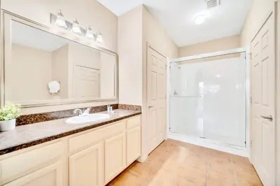 a bathroom with a sink and a mirror at 2BR Condo with shared Pool near Disney! in Orlando