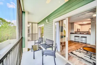 a porch with chairs and a table on a balcony at 2BR Condo with shared Pool near Disney! in Orlando