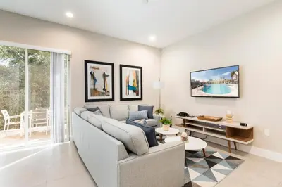 a living room with a couch and a table at Stylish Family Villa 5min Disney BBQ 1804ft in Orlando