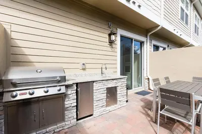 a outdoor kitchen with a grill and a table on a patio at Stylish Family Villa 5min Disney BBQ 1804ft in Orlando