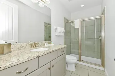 a white bathroom with a toilet and a shower at Marvelous Home Near Disney With Private Pool And Waterpark & Resort Access At Encore Resorts Reunion - 250Cl in Kissimmee