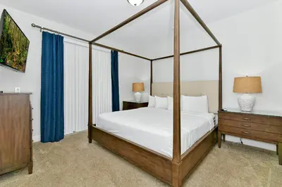 a bedroom with a canopy bed and a dresser at Marvelous Home Near Disney With Private Pool And Waterpark & Resort Access At Encore Resorts Reunion - 250Cl in Kissimmee