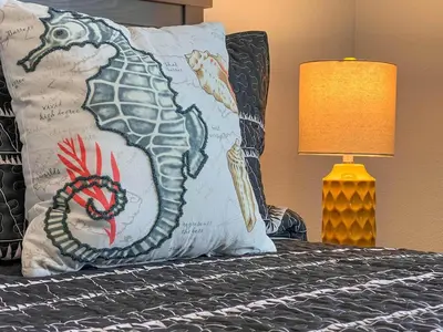 a pillow with a dragon on a bed with a lamp at Storey Lake Pool Mins to Disney 4BR Games in Kissimmee