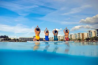 a group of people sitting on surfboards in a swimming pool at Evermore Orlando Resort in Orlando