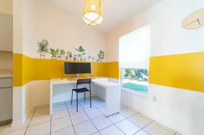 a room with a desk with a monitor and a chair at Newly Updated 3 Bedroom Home in Kissimmee