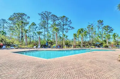 a swimming pool in a park with palm trees at Stunning 2BR Condo with Pool, near Disney! in Orlando