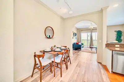 a dining room and living room with a table and chairs at Stunning 2BR Condo with Pool, near Disney! in Orlando