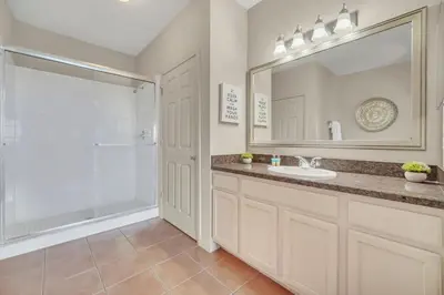 a bathroom with a sink and a shower and a mirror at 2BR Condo with pool, near Disney! in Orlando