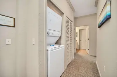 a kitchen with a washer and dryer in a room at Bright 3BR Condo With Pool, Close to Disney! in Orlando