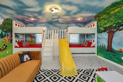 a childs bedroom with a mural of a tree at Mickey Mouse ClubHouse 8min Disneyworld Pool Spa Sleeps 20 in Kissimmee