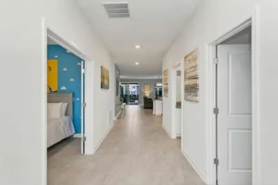 a room with a bed and a hallway with white doors at Amazing Family Home 8min Disneyworld Pool/Spa Sleeps 24 in Kissimmee