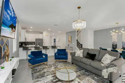 a living room with a couch and blue chairs at Amazing Family Home 8min Disneyworld Pool/Spa Sleeps 24 in Kissimmee