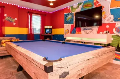 a room with a pool table in a play room at Disney Decorated Home 8min Disneyworld Pool/Spa Sleeps 22 in Kissimmee