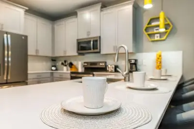 a kitchen with two cups and plates on a counter at Disney Decorated Home 8min Disneyworld Pool/Spa Sleeps 22 in Kissimmee