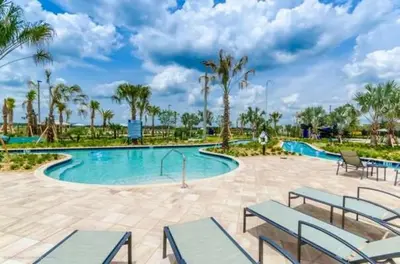 a large swimming pool with benches and palm trees at Disney Decorated Home 8min Disneyworld Pool/Spa Sleeps 22 in Kissimmee