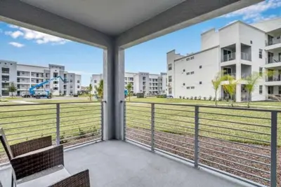 a balcony with a view of a field and buildings at 3 BR 2 BA Deluxe Condo 8min to Disneyworld STL105 in Kissimmee