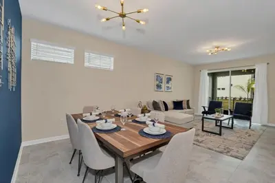 a dining room and living room with a table and chairs at 3 BR 2 BA Deluxe Condo 8min to Disneyworld STL105 in Kissimmee