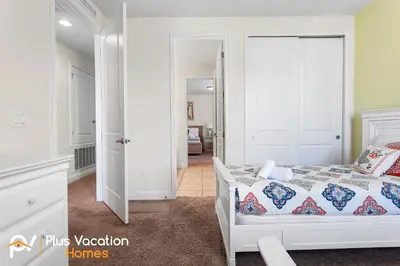 a white bedroom with a bed and a hallway at 361 Pendant ct in Orlando