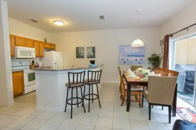 a kitchen and dining room with a table and chairs at Peaceful Quiet Pool Home 5 min from Disney! townhouse in Orlando