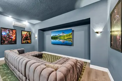 a movie room with a large couch in the corner at Alluring Home With Private Pool And Waterpark & Resort Access Near Disney At Encore Resorts Reunion - 280Sf in Kissimmee