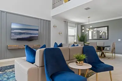a living room with a couch and blue chairs at Beautiful Family Villa - Pool and Hot Tub - Near Disney World in Kissimmee