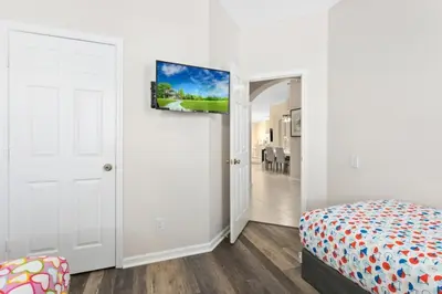 a bedroom with white walls and a bed and a door at South Facing Pool 4 Bedroom 3 Bath Villa villa in Kissimmee
