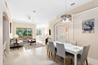 a dining room and living room with a table and chairs at South Facing Pool 4 Bedroom 3 Bath Villa villa in Kissimmee