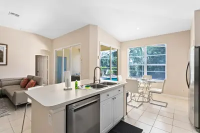 an open kitchen and living room with a couch at South Facing Pool 4 Bedroom 3 Bath Villa villa in Kissimmee