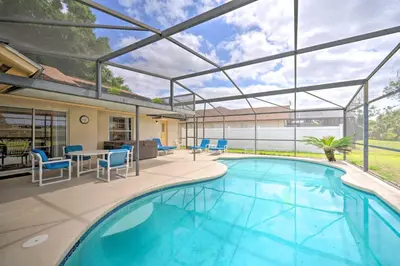 an indoor swimming pool with a patio with a table and chairs at about 5 Mi to Theme Parks Kissimmee Home with Pool in Orlando