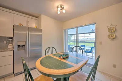 a kitchen and dining room with a table and a refrigerator at about 5 Mi to Theme Parks Kissimmee Home with Pool in Orlando