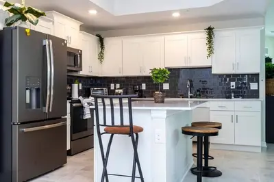 a kitchen with white cabinets and a black refrigerator at Gorgeous 3Bd 2Ba Apt Close to Disney @ Storey Lake Orlando 208 3180 in Kissimmee