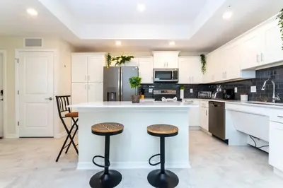a kitchen with white cabinets and a counter with stools at Gorgeous 3Bd 2Ba Apt Close to Disney @ Storey Lake Orlando 208 3180 in Kissimmee
