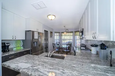 a kitchen with white cabinets and a counter top at South Facing Pool with Stunning Lake View - Family Friendly Home - Nr Disney in Kissimmee
