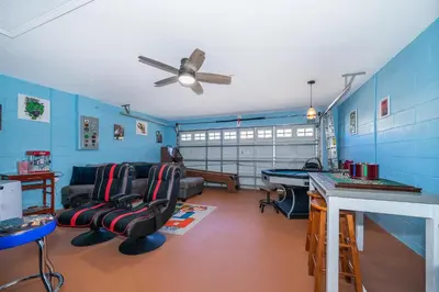 a living room with blue walls and a ceiling fan at South Facing Pool with Stunning Lake View - Family Friendly Home - Nr Disney in Kissimmee