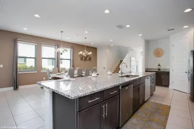 a large kitchen with a large island with a counter top at Stylish Family Home Private Pool/Spa 10min Disneyworld Sleeps 22 in Orlando
