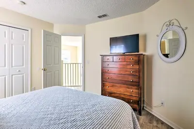 a bedroom with a bed and a tv on a dresser at Less Than 5 Mi to Disney World Resort Home for Families! in Kissimmee