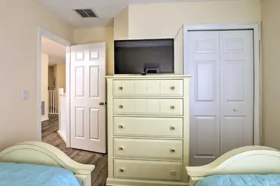 a bedroom with a dresser with a tv on top of it at Less Than 5 Mi to Disney World Resort Home for Families! in Kissimmee