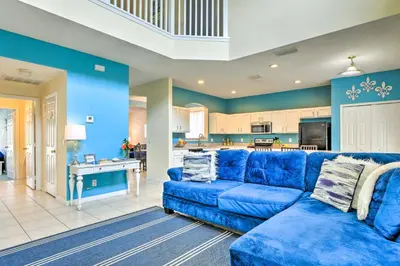 a blue couch in a living room with a kitchen at Less Than 5 Mi to Disney World Resort Home for Families! in Kissimmee