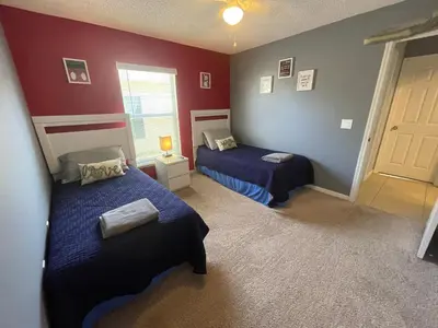 two beds in a room with red walls at 3 Bedroom Villa with Poolside Cinema and Games Room Close to theme Parks sleeps 6 in Orlando