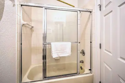 a bathroom with a shower with a glass door at Disney-Inspired Townhome with Private Hot Tub! in Orlando