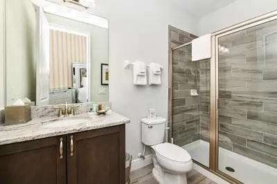 a bathroom with a toilet and a sink and a shower at Utopic Home With Themed Rooms, Game And Media Room And Waterpark & Resort Access Near Disney At Encore Resorts Reunion - 270Cl in Kissimmee