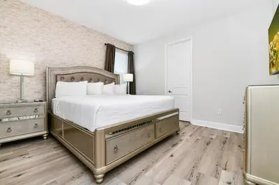 a bedroom with a bed with white sheets and wooden floors at Utopic Home With Themed Rooms, Game And Media Room And Waterpark & Resort Access Near Disney At Encore Resorts Reunion - 270Cl in Kissimmee