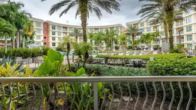 a view of a resort with palm trees and tables and chairs at Hotel Apt at Celebration 10 min from Disney MH225 in Orlando