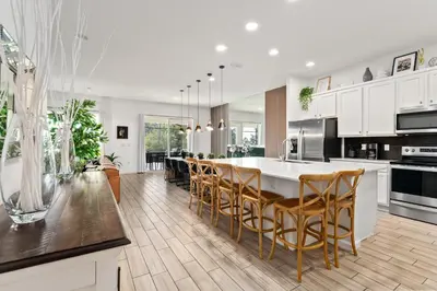 a kitchen with white cabinets and a table and chairs at Fresh Amazing Family Home. Private Pool. Game Room. Sleeps 24 in Kissimmee