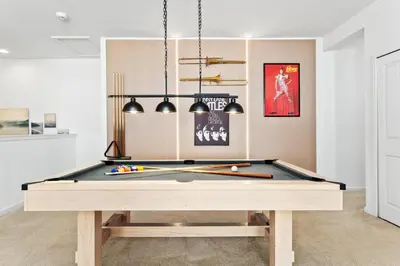a pool table with balls and bats on it at Fresh Amazing Family Home. Private Pool. Game Room. Sleeps 24 in Kissimmee